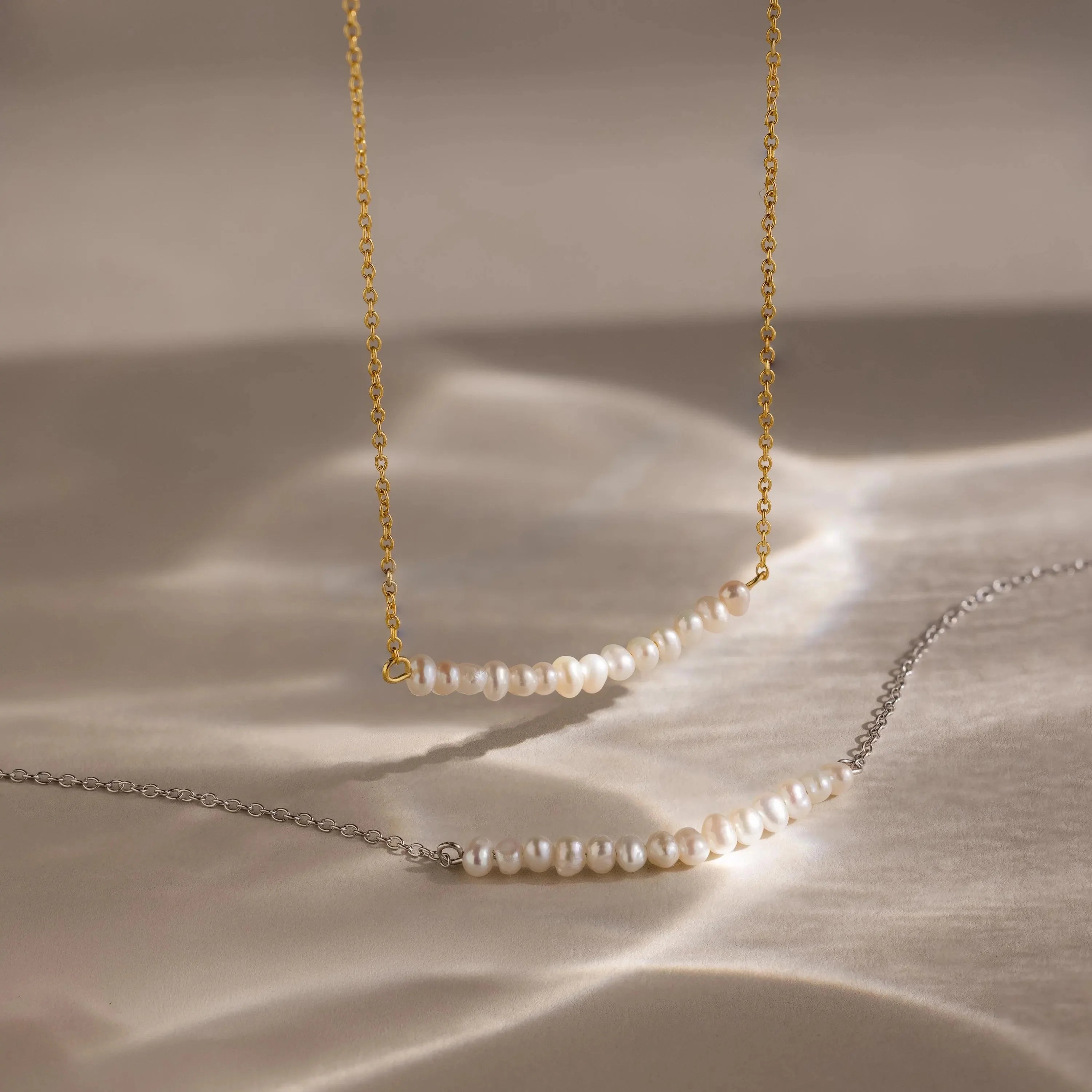 Elegant pearl curve necklace with a sleek design, featuring smooth, lustrous pearls arranged in a gentle arc.